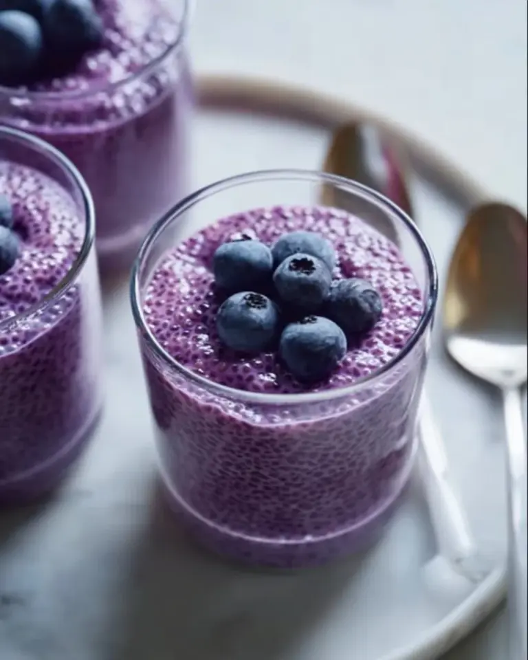 Delicious blueberry chia seed pudding in a glass topped with fresh blueberries