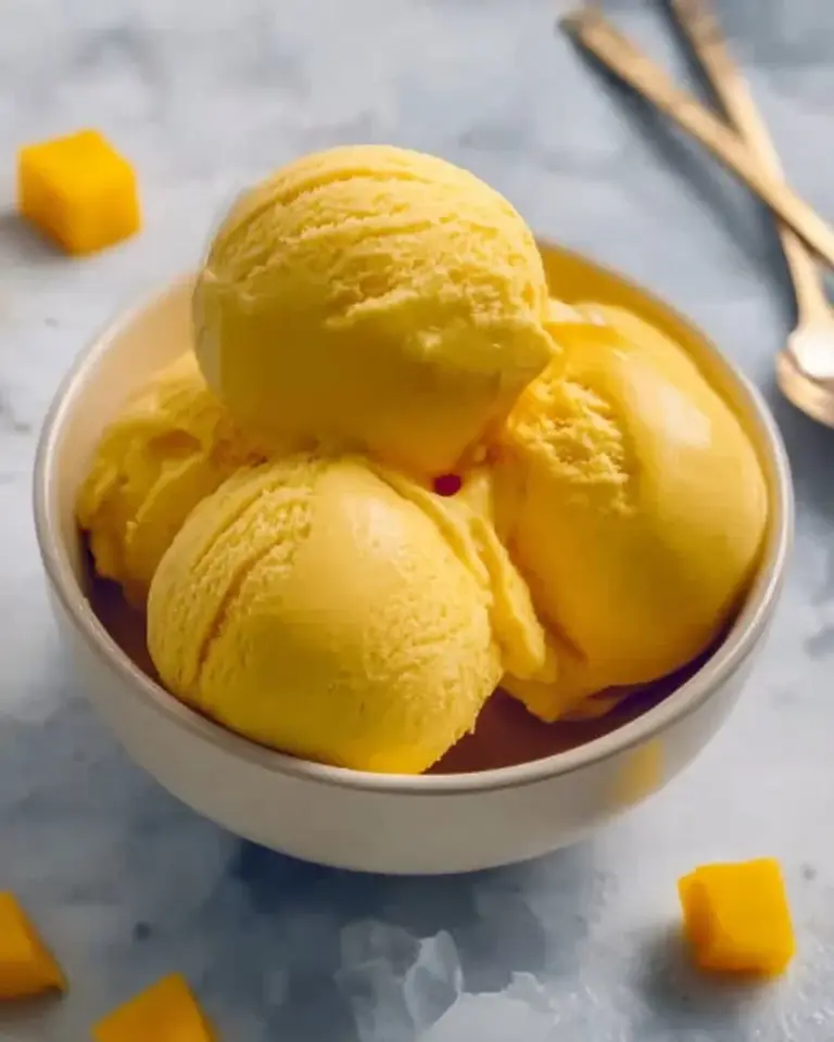Homemade easy mango ice cream served in a bowl with fresh mango slices