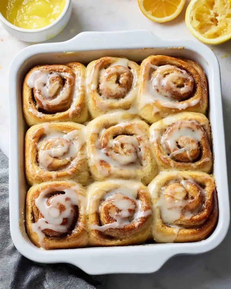 Freshly baked Lemon Poppy Seed Rolls with a lemon glaze and poppy seeds.