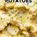 Creamy crockpot mashed potatoes in a bowl, garnished with herbs.